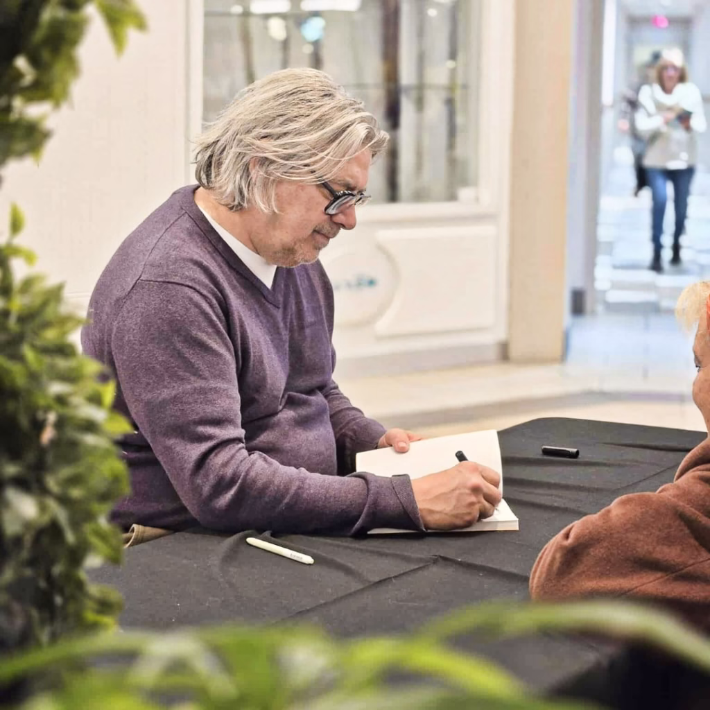 L'ecrivain Michel Jean en train de signer son livre pour l'occasion